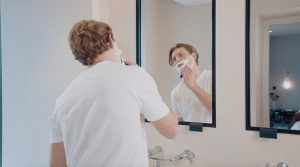 Man shaving with shaving foam. Comparison of mens shaving products.